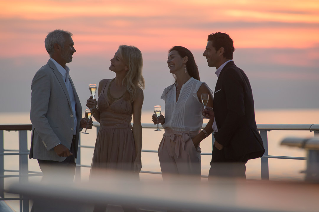 Enjoying champagne in the sunset is just one way to spend time onboard <em>Le Dumont d’Urville</em>. 